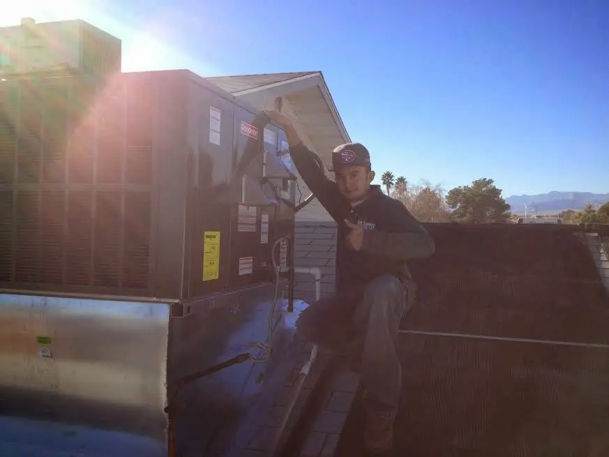 HVAC technician performing HVAC Inspection on a rooftop unit in Jericho